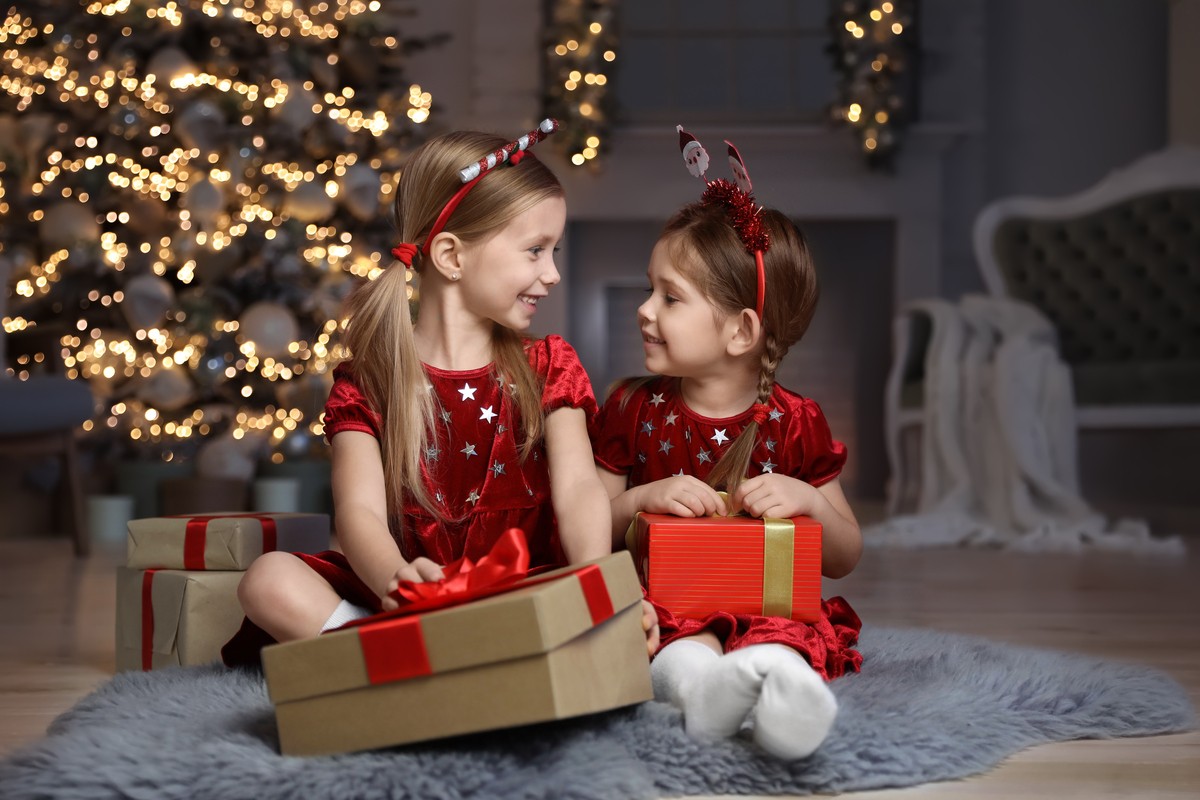 Children with Christmas gifts in daycare room
