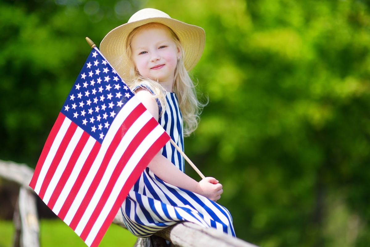 Cute little girl holding American flag
